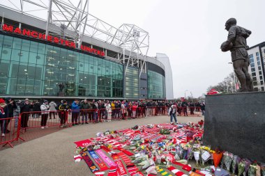 Çiçekler ve eşarplar, Manchester United ve Hove Albion maçında Old Trafford, Manchester, Birleşik Krallık 'ta 19 Ocak 2025' te oynanan Premier League karşılaşmasında Old Trafford 'un önündeki Dennis Law anısına dikilmiştir.