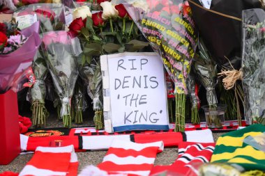 Flowers, notes, scarfs are laid tribute to late Dennis Law outside of Old Trafford in front of his statue during the Premier League match Manchester United vs Brighton and Hove Albion at Old Trafford, Manchester, United Kingdom, 19th January 2025 clipart