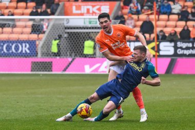 Blackpool 'dan Elkan Baggott ve Huddersfield Town' dan Rhys Healey 18 Ocak 2025 'te Bloomfield Road, Blackpool' da oynanan Blackpool-Huddersfield maçında top için mücadele ettiler.