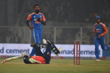 England's captain Jos Buttler falls on the ground in an attempt to play a shot on a delivery by India's Hardik Pandya, left, during the first T20 cricket match between India and England at Eden Gardens in Kolkata, India, Wednesday, Jan. 22, 2025.  clipart