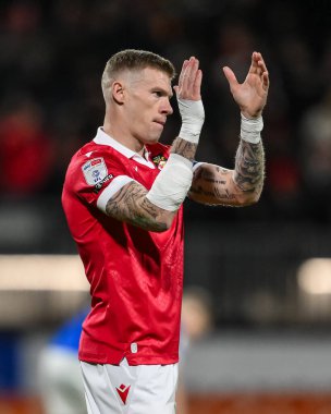 Wrexham 'dan James McClean, Wrexham-Birmingham maçı sırasında, Wrexham-Birmingham City, Wrexham, Wrexham, Birleşik Krallık, 23 Ocak 2025' te geçirdiği araba kazasında kolları ve elleri bandajlı taraftarları alkışlıyor.