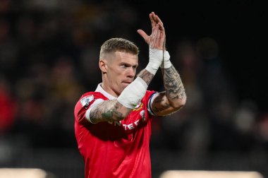 Wrexham 'dan James McClean, Wrexham-Birmingham maçı sırasında, Wrexham-Birmingham City, Wrexham, Wrexham, Birleşik Krallık, 23 Ocak 2025' te geçirdiği araba kazasında kolları ve elleri bandajlı taraftarları alkışlıyor.
