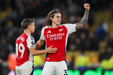 Arsenal 'den Riccardo Calafiori ve Arsenal' den Leandro Trossard, 25 Ocak 2025 'te Molineux, Wolverhampton, Birleşik Krallık' ta oynanan Premier League maçının sonunda kazandığı galibiyeti kutluyorlar.