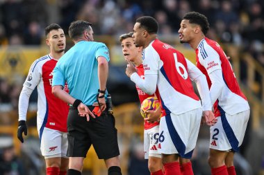Arsenal oyuncuları, 25 Ocak 2025 'te Molineux, Wolverhampton, İngiltere' de oynanan Premier League maçında Arsenal 'den Myles Lewis-Skelly' ye kırmızı kart verdikten sonra hakem Michael Oliver 'ı köşeye sıkıştırdı.