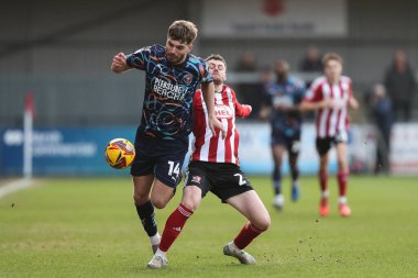 Blackpool 'dan Tom Bloxham, Exeter City' den Jack McMillan 'ın 25 Ocak 2025' te St James 'Park, Exeter, İngiltere' de oynanan Sky Bet 1 maçı sırasında meydan okumasından kaçıyor.