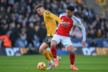 Jrgen Strand Larsen of Wolverhampton Wanderers and William Saliba of Arsenal battle for the ball during the Premier League match Wolverhampton Wanderers vs Arsenal at Molineux, Wolverhampton, United Kingdom, 25th January 2025 clipart