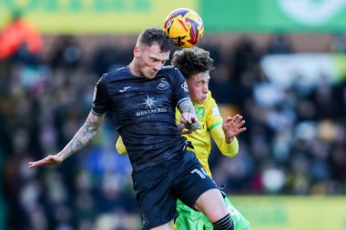Swansea City 'den Josh Tymon, Norwich City' nin Norwich City 'ye karşı Swansea City maçında Norwich City' den Oscar Schwartau ile birlikte 25 Ocak 2025 'te Carrow Road, Norwich' te topa atlıyor.
