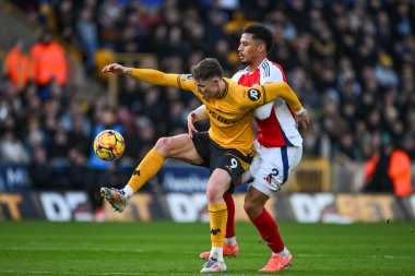 Jrgen Strand Larsen of Wolverhampton Wanderers and William Saliba of Arsenal battle for the ball during the Premier League match Wolverhampton Wanderers vs Arsenal at Molineux, Wolverhampton, United Kingdom, 25th January 2025 clipart