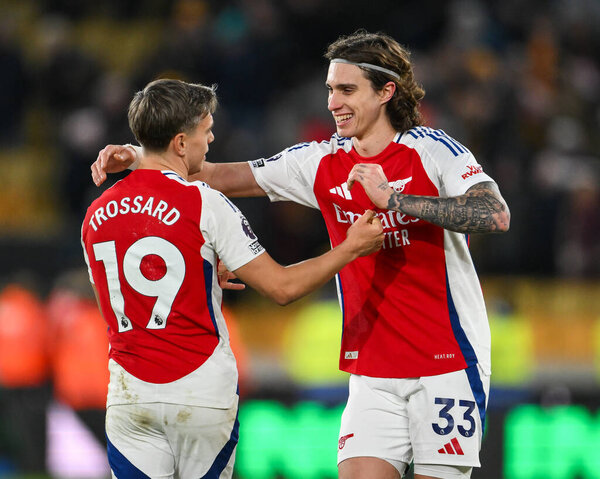 Riccardo Calafiori of Arsenal and Leandro Trossard of Arsenal celebrates his sides victory at the end of the Premier League match Wolverhampton Wanderers vs Arsenal at Molineux, Wolverhampton, United Kingdom, 25th January 2025