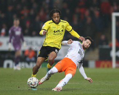 Blackpool 'dan James Husband topu pas atarken, Burton Albion' dan Rumarn Burrell 8 Şubat 2025 tarihinde İngiltere 'de Pirelli Stadyumu' nda Burton Albion 'a karşı Blackpool maçında topu sürüyor.