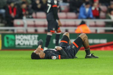 Luton Town 'dan Reuell Walters, 12 Şubat 2025' te Sunderland-Luton Town Stadyumu 'nda oynanan Gökyüzü İddia Şampiyonası maçında topa serbest vuruşla vurduktan sonra yerde yatıyor.