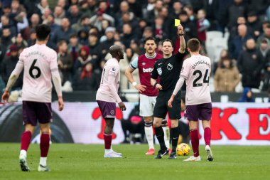 Hakem Darren England, Premier League maçında Brentford 'dan Mikkel Damsgaard' a sarı kart gösteriyor. West Ham United, Brentford 'a karşı Londra Stadyumu, Londra, İngiltere, 15 Şubat 2025