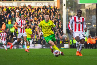 Norwich City 'den Josh Sargent, Stoke City' den Junior Tchamadeu. 22 Şubat 2025 'te Norwich City, Norwich City' ye karşı Stoke City 'nin 22 Şubat 2025' te oynadığı maçta top için mücadele ediyor.