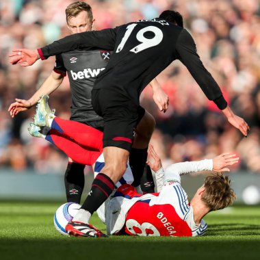 Arsenal 'den Martin Odegaard, 22 Şubat 2025' te Birleşik Krallık 'taki Emirates Stadyumu' nda oynanan Premier League karşılaşmasında West Ham United 'dan Edson Alvarez' e meydan okudu.