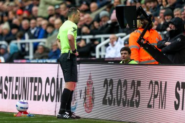 Hakem Jarred Gillett, Premier Lig maçı sırasında İngiltere 'nin Newcastle kentindeki St. James' s Park 'ta oynanan Newcastle United - Nottingham Forest maçında hentbol oynayan video hakem yardımcısını kontrol ediyor.