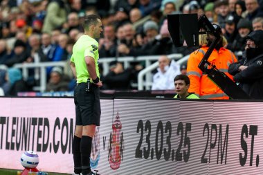 Hakem Jarred Gillett, Premier Lig maçı sırasında İngiltere 'nin Newcastle kentindeki St. James' s Park 'ta oynanan Newcastle United - Nottingham Forest maçında hentbol oynayan video hakem yardımcısını kontrol ediyor.