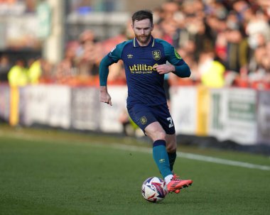 Huddersfield Town 'dan Oliver Turton, 1 Mart 2025 tarihinde İngiltere' nin Stevenage kentindeki Lamex Stadyumu 'nda oynanan Sky Bet 1 karşılaşmasında ileri pas attı.