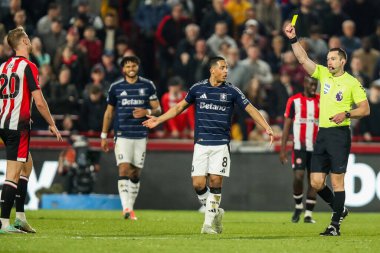 Hakem Jarred Gillett, Brentford 'lu Kristoffer Ajer' a Premier League maçında Brentford, Aston Villa 'ya karşı Gtech Community Stadyumu, Londra, Birleşik Krallık' ta 8 Mart 2025 'te oynanan sarı kartı gösteriyor.