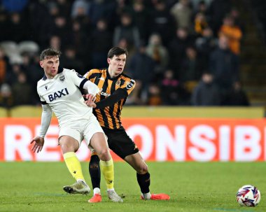 Oxford United takımından Mark Harris, Hull City 'nin 12 Mart 2025' te MKM, Hull, İngiltere 'deki Oxford United maçında Hull City ile oynadığı Sky Bet Şampiyonası maçında Hull City' den Alfie Jones 'un baskısı altında.