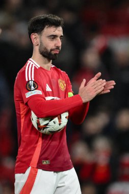Manchester United takımından Bruno Fernandes, UEFA Avrupa Ligi son 16 maçında Manchester United - Real Sociedad maçında Old Trafford, Manchester, İngiltere, 13 Mart 2025 'te hat-trick yaptıktan sonra maç topunu topluyor.