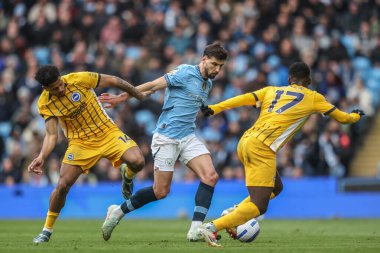 Manchester City 'den Rben Dias, İngiltere' nin Etihad Stadyumu 'nda oynanan Premier Lig karşılaşmasında Brighton & Hove Albion takımından Georginio Rutter ve Yankuba Minteh' i geçti.