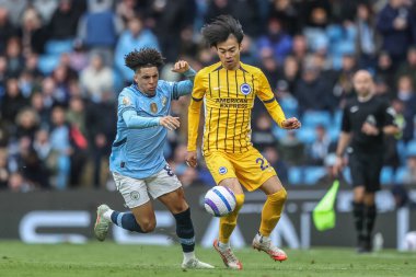 Manchester City 'den Rico Lewis ve Brighton & Hove Albion' dan Kaoru Mitoma Premier Lig karşılaşması sırasında Manchester City - Brighton ve Hove Albion 'a karşı Etihad Stadyumu, Manchester, İngiltere, 15 Mart 2025