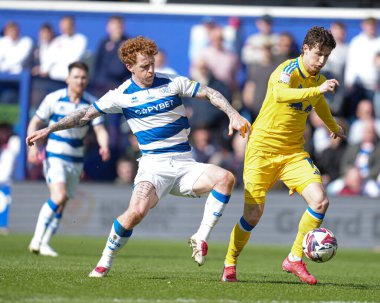 Queens Park Rangers 'dan Jack Colback, Leeds United takımından Brenden Aaronson' ı 15 Mart 2025 'te Londra' daki Kiyan Prince Foundation Stadyumu 'nda Queens Park Rangers - Leeds United maçında yenmeye çalıştı.