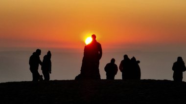 İnsanlar güneşin doğuşunu izlemek için Mam Tor 'un zirvesine gidiyorlar. 19 Mart 2025' te Mam Tor, Peak District, Birleşik Krallık 'taki Hope Vadisi' nin üzerinde bir sis örtüsü olarak duruyorlar.