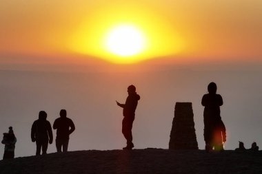 İnsanlar güneşin doğuşunu izlemek için Mam Tor 'un zirvesine gidiyorlar. 19 Mart 2025' te Mam Tor, Peak District, Birleşik Krallık 'taki Hope Vadisi' nin üzerinde bir sis örtüsü olarak duruyorlar.