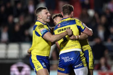 Matty Ashton, Warrington Wolves 'tan Ben Currie ve George Williams ile 21 Mart 2025' te St Helens vs Warrington Wolves 'a karşı oynadığı Betfred Süper Lig karşılaşmasında denemesini kutluyor. 