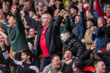 Wrexham taraftarları zaferlerini 22 Mart 2025 'te İngiltere' nin SToK Cae Ras, Wrexham kentinde oynanan Wrexham - Stockport County maçının ardından kutluyorlar.