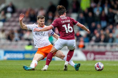Northampton Town 'dan Terry Taylor, 22 Mart 2025 tarihinde İngiltere' nin Northampton şehrindeki Sixfields Stadyumu 'nda oynanan Sky Bet League 1 maçı sırasında Blackpool' dan Lee Evans 'a meydan okudu.