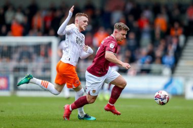 Northampton Town 'dan Sam Hoskins, Blackpool' dan Sonny Carey 'nin baskısı altında. 21 Mart 2025 tarihinde Northampton Town, Northampton Stadyumu' ndaki Blackpool maçında.