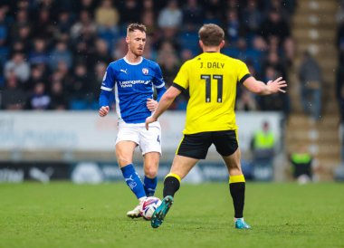 Chesterfield 'dan Tom Naylor, Harrogate Town' dan James Daly 'nin 22 Mart 2025' te SMH Group Stadiumact Stadyumu 'nda oynanan Sky Bet 2 karşılaşmasında baskısı altında.