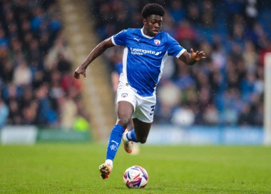 Chesterfield 'den Michael Olakigbe, 22 Mart 2025' te İngiltere 'nin Chesterfield kentinde oynanan SMH Group Stadyumu' nda oynanan Harrogate Town maçında topla birlikte ilerliyor.