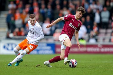 Northampton Town 'dan Ben Perry, Blackpool' dan Sonny Carey 'nin baskısı altında. 21 Mart 2025 tarihinde Northampton Town - Blackpool maçında.