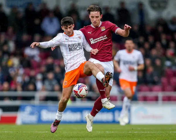 Blackpool 'dan Rob Apter Northampton Town' dan Terry Taylor ile 22 Mart 2025 'te Northampton Town' a karşı Blackpool maçında top için mücadele ediyor.