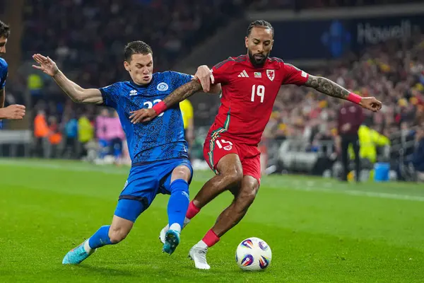 Galler 'den Sorba Thomas, 22 Mart 2025' te Cardiff City Stadyumu 'nda oynanan FIFA Dünya Kupası elemeleri sırasında Kazakistan' lı İslam Chesnokov 'un baskısı altında Galler - Kazakistan maçı sırasında