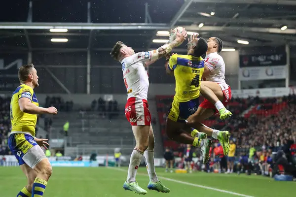 St. Helens 'ten Mark Percival, Betfred Süper Lig 5. Raundu' nda Warrington Wolves 'tan Rodrick Tai' nin önünde topu yakaladı. St Helens - Warrington Wolves maçı, St Helens, St Wicked Stadyumu, Birleşik Krallık, 21 Mart 2025