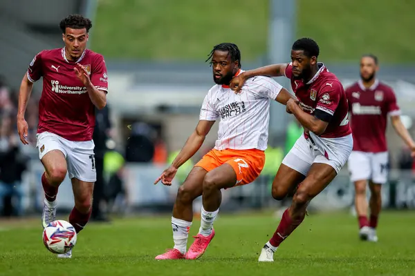 Blackpool 'dan Josh Onomah, 22 Mart 2025' te Northampton 'daki Sixfields Stadyumu' nda Northampton Town - Blackpool maçı sırasında Northampton Town 'dan Liam McCarron ve Tyler Magloire ile top mücadelesi veriyor.