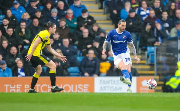 Chesterfield 'dan Oliver Banks, Harrogate Town' dan Ben Fox 'un baskılarına rağmen 22 Mart 2025' te SMH Group Stadiumact Stadyumu 'ndaki Chesterfield-Harrogate Town maçında pas attı.