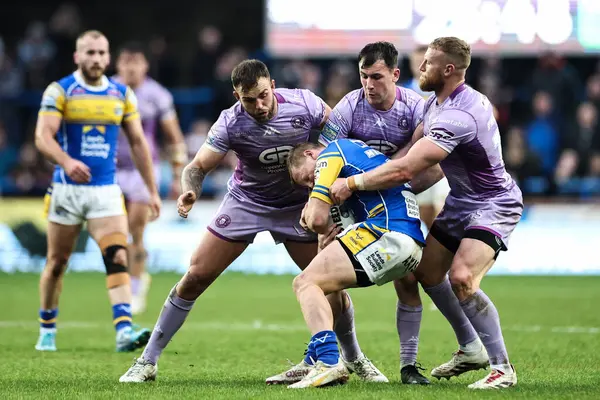 Leeds Rhinos 'tan Lachlan Miller, Wigan Warriors' tan Luke Thompson ve Wigan Warriors 'tan Harry Smith tarafından oynanan Betfred Süper Lig 5. Raundunda Leeds Gergedan' a karşı Wigan Warriors maçı sırasında Headingley Stadyumu, Leeds, İngiltere 'de 22 Mart 2025' te yenildi.