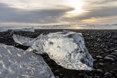 25 Mart 2025 'te Jkulsrln Buzul Gölü, Jkulsrln, İzlanda' dan nehrin aşağısında yüzen Elmas Plajı 'nda küçük buzdağı kıyıya vurdu.