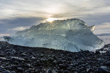 25 Mart 2025 'te Jkulsrln Buzul Gölü, Jkulsrln, İzlanda' dan nehrin aşağısında yüzen Elmas Plajı 'nda küçük buzdağı kıyıya vurdu.