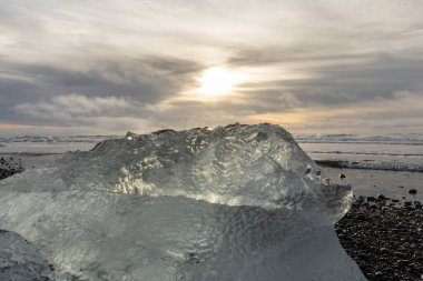 25 Mart 2025 'te Jkulsrln Buzul Gölü, Jkulsrln, İzlanda' dan nehrin aşağısında yüzen Elmas Plajı 'nda küçük buzdağı kıyıya vurdu.
