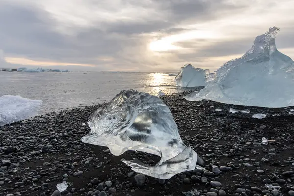 25 Mart 2025 'te Jkulsrln Buzul Gölü, Jkulsrln, İzlanda' dan nehrin aşağısında yüzen Elmas Plajı 'nda küçük buzdağı kıyıya vurdu.