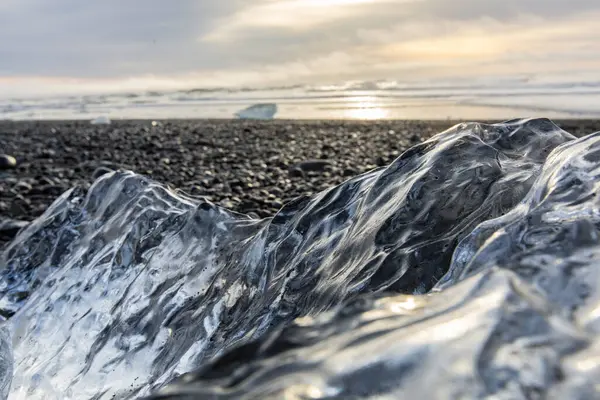 25 Mart 2025 'te Jkulsrln Buzul Gölü, Jkulsrln, İzlanda' dan nehrin aşağısında yüzen Elmas Plajı 'nda küçük buzdağı kıyıya vurdu.