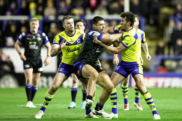 Ryan Hall of Leeds Rhinos, Warrington Wolves 'tan Stefan Ratchford tarafından oynanan Betfred Süper Lig 6. Raundu karşılaşmasında Halliwell Jones Stadyumu, Warrington, İngiltere' de oynanan Warrington, 28 Mart 2025