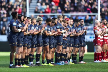 Her iki oyuncu da, 30 Mart 2025 'te İngiltere' nin başkenti Wigan 'daki The Brick Community Stadyumu' nda oynanan 6. Wigan Warriors - Salford Red Devils maçında hayatını kaybeden iki Wigan taraftarını dakikalar içinde alkışlıyor.