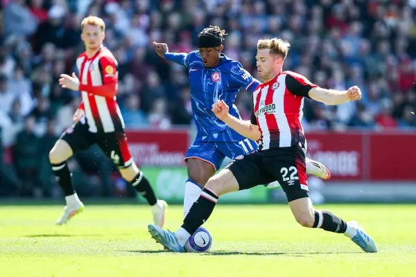 Chelsea 'den Noni Madueke Premier Lig karşılaşmasında Brentford' lu Nathan Collins ile birlikte Londra 'daki Gtech Community Stadyumu' nda 6 Nisan 2025 'de oynanan karşılaşmada top için mücadele ediyor.